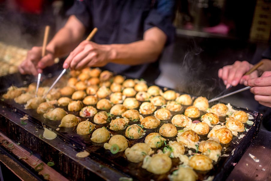 Treat your tastebuds to takoyaki, a dumpling-like, crispy snack in Dotonbori